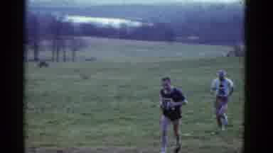 Boston Mass USA (1975): Two Men Running With Each Other On Grass Field In A