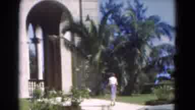 Florida USA (1975): Woman Wearing White Shirt Walks To House On A Bright Sunny Day