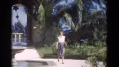 Florida USA (1975): Women In White Blouse And Blue Skirts Stands By Shrubs In