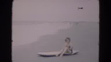 Florida USA (1975): A Lady In A Swimsuit Sits On A Raft On The Beach Beside The