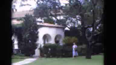 Florida USA (1975): Woman In A Blue Dress Walking On A Well Manicured Lawn Past A