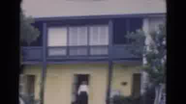 Florida USA (1975): Woman Wearing Black Bathing Suit Walks On Beach While Man
