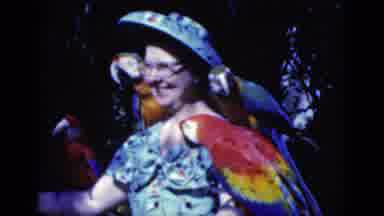Florida USA (1975): Woman Spinning With Macaw Birds On Her Shoulders At Indoor