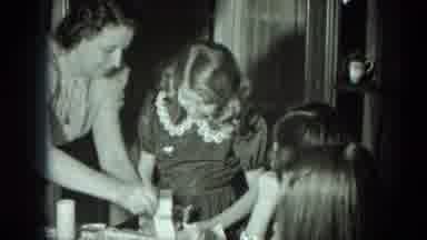 West Germany (1951): Excited Girl Opening A Small Box With Her Family Gathered And