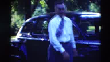 Paducah Kentucky USA (1951): Man Wearing White Shirt Walks Around Black Car On A