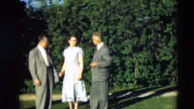 Paducah Kentucky USA (1951): Woman Wearing Blue Dress Stands Between Two Men