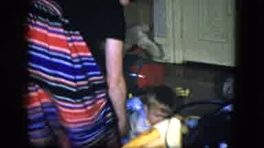 Cleveland Ohio (1951): Woman Helps Baby Wearing Blue Play With Christmas Gifts