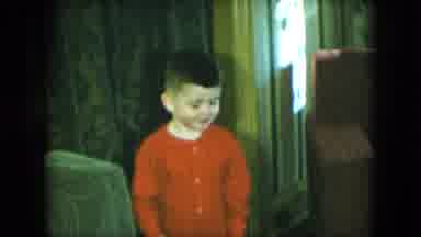 Cleveland Ohio (1951): Child Plays Around Christmas Presents Indoors While Wearing