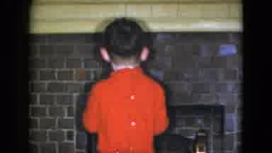 Cleveland Ohio (1951): Little Boy Puts Christmas Ornament On The Fireplace In His