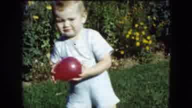 Cleveland Ohio (1951): Young Boy Picks Up A Red Balloon In A Park