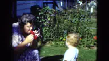 Cleveland Ohio (1951): A Woman Blowing Bubbles And A Toddler Looking At Them