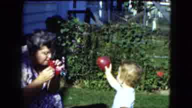 Cleveland Ohio (1951): A Woman Blowing Bubbles For A Small Child That Is Playing