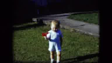 Cleveland Ohio (1951): Baby Wearing Blue Shorts Walks Holding Small Red Object
