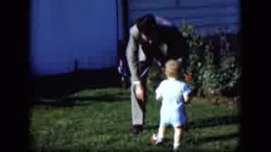 Cleveland Ohio (1951): Man Plays With Child In Grassy Outdoor Area On Sunny Day