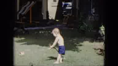 Cleveland Ohio (1951): A Child Is Playing Near The House Holding Water Pipe