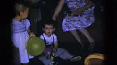 Cleveland Ohio (1951): Young Child Picked Up By Adult And Placed In Chair In Front