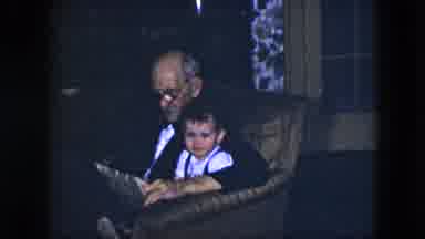 Cleveland Ohio-1951: Sweet Older Man Reading A Newspaper To A Little Boy Sitting On His Lap