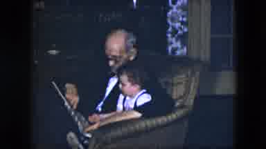Cleveland Ohio (1951): Grandfather Sits Baby Grandson In His Lap And Reads Him A