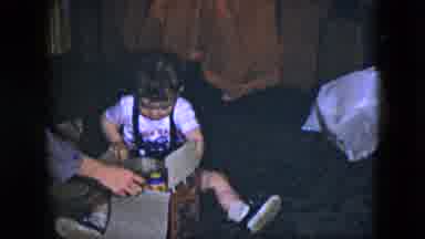 Cleveland Ohio (1951): Young Boy In Overalls Opens Up A Gift On His Birthday