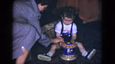 Cleveland Ohio (1951): Woman Helping A Little Boy Sitting On A Floor Figure Out A