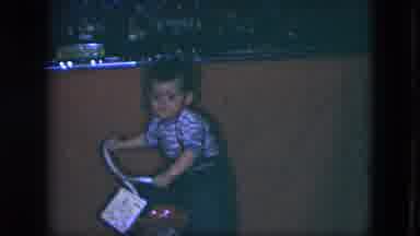 Cleveland Ohio (1951): Boy Wearing Blue Overalls Sits On Red Tricycle With White