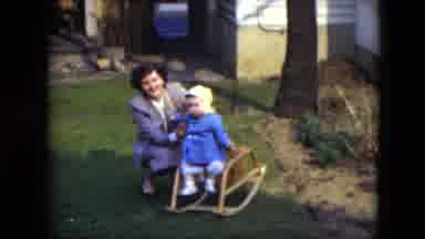 Cleveland Ohio (1951): Baby Wearing Blue Coat Sits In Small Rocking Booster Chair