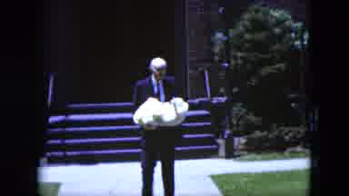 Cleveland Ohio (1951): Old Man Walking While Holding A Baby And Leaving A Building