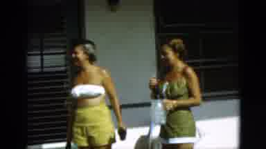 Quebec Canada (1952): Two Tanned Women Standing Outdoors And One Gives A Bottle To