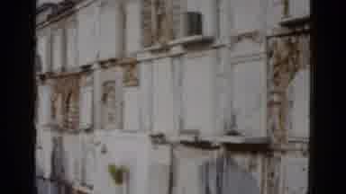 New Orleans USA (1952): Woman Wearing Grey Suit Stands By White Pillar And Black