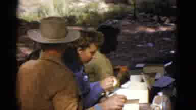 Arizona USA (1952): Man Wearing Tan Hat Feeds Deer While Others Eat At Picnic