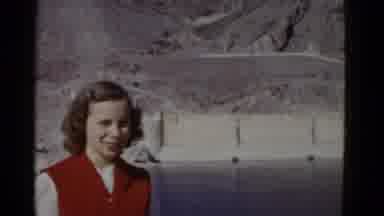 California USA (1952): A Lady In Red Stands By The Water And A Dam