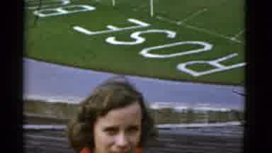 California USA (1952): A Woman In Orange Coat Standing Besides The Football Field