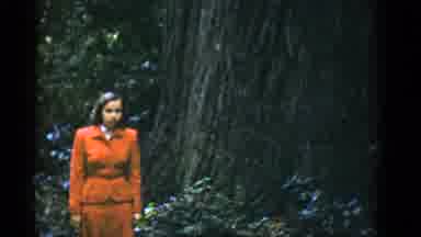 San Francisco California (1952): Woman Wearing Red Suit Stands By Tree Then Walks