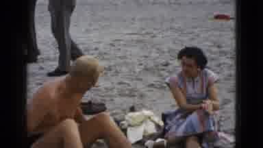 California USA (1953): Man Sat On The Beach In Underwear Amongst Other Clothed