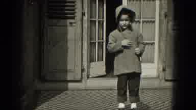 Milwaukee Wisconsin (1953): Small Child Wearing Coat And Hood Standing On Porch