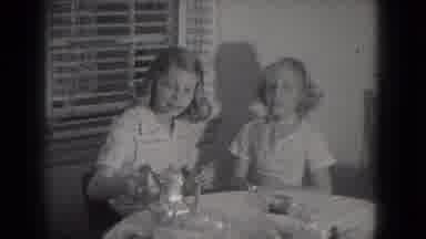 Milwaukee Wisconsin (1953): Girl Lifting Silver Teapot While Sitting At A White