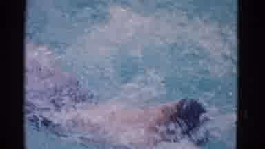 Yonkers New York (1953): Boy In Black Swim Trunks Practices The Backstroke In A