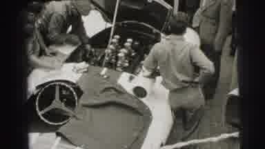 Le Mans France (1954): Mechanics Work On The Motor Of A Race Car As Spectators