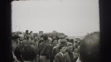 Le Mans France (1954): Standing Spectators Watch Race Cars Pass Under An Arch