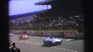 Le Mans France (1954): Race Cars Ride Along A Track While The Crowd Cheers From