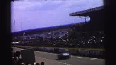 Le Mans France (1954): Race Cars Pace By The Packed Stands Of A Race Track As Fans