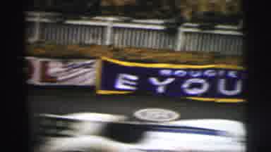 Le Mans France (1954): A View Of Signage At A Race Track With Race Cars Speeding