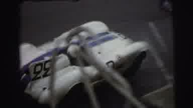 Le Mans France (1954): Blue And White Race Car Zooms Down The Track As People In