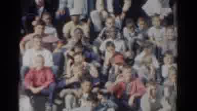 California USA (1954): Large Group Of People Smiling And Waving As They Sit