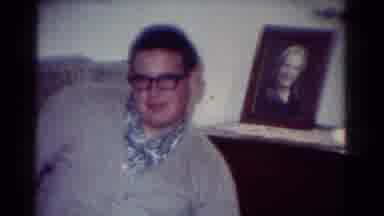 Toledo Ohio USA (1954): Man Awkwardly Posing Near Two Framed Photos Of A Man And