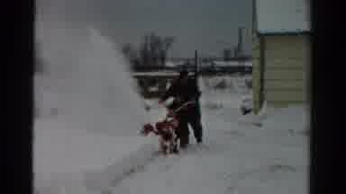 Toledo Ohio USA (1954): Man Wearing Black Snowsuit Uses Snowblower On A Clear