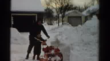 Toledo Ohio USA (1954): Adult Helps Child Push Snowblower Near Garage After Heavy