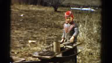 Toledo Ohio USA (1954): Child Outside Wearing Hat And Jacket Playing With Metal