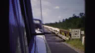 Dade County Florida (1955): A Car Driving Down A Road With A Guard Rail Showing