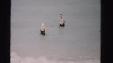 Dade County Florida (1955): Woman And Man Wearing Swim Suits Wade Into Surf At An